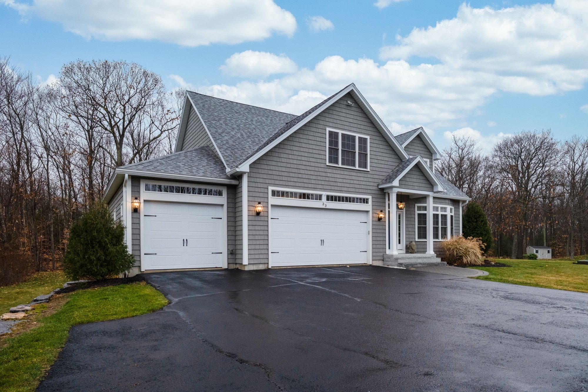 gray-walled-suburban-house-with-white-asphalt-driv-2025-02-11-17-57-29-utc